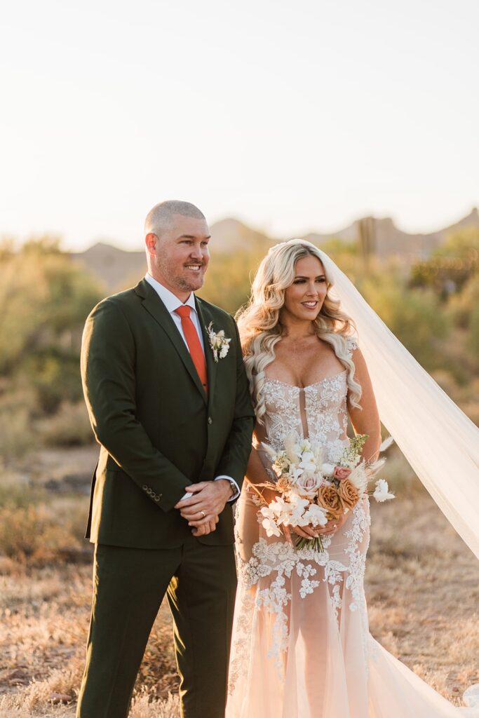 Bride and groom standing together during their outdoor ceremony at The Paseo, bathed in warm desert light.