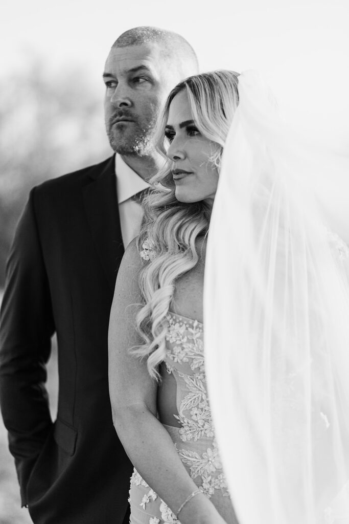 Black and white portrait of bride and groom during golden hour at The Paseo, Arizona desert landscape behind them.