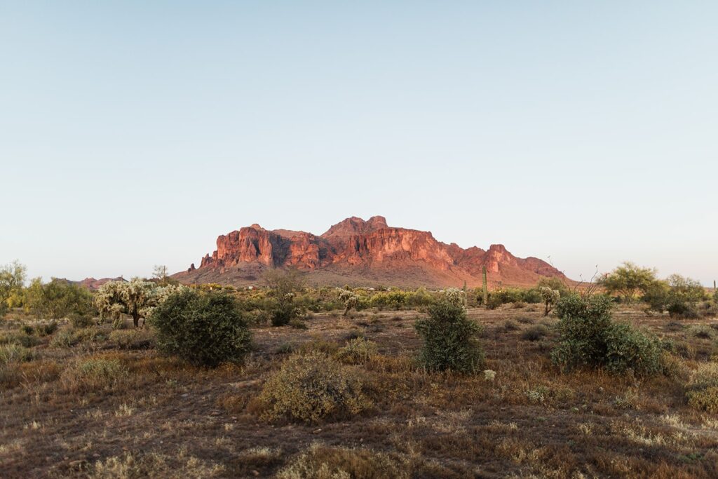 Wide view of the Superstition Mountains under soft evening light, seen from the ceremony site at The Paseo wedding venue.

